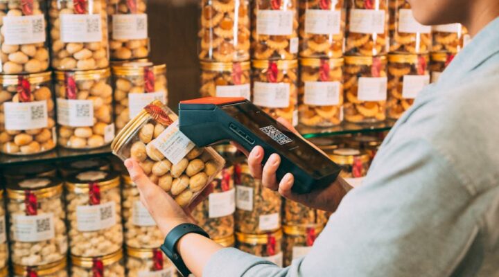 Close up of a smart packaging label with glowing NFC chip QR code scanning to AR product demo on smartphone and data visualization dashboard showing supply chain tracking