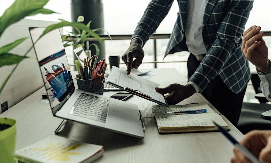 Close up of a sustainability manager analyzing packaging data dashboards on a laptop with sample cartons and paper bags on the desk Close up of a sustainability manager analyzing packaging data dashboards on a laptop with sample cartons and paper bags on the desk