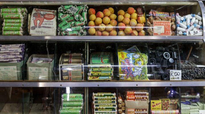 Vibrant retro packaging display on a store shelf with s style candy boxes soda bottles and cereal cartons in warm earth tones and bold typography evoking mid century nostalgia