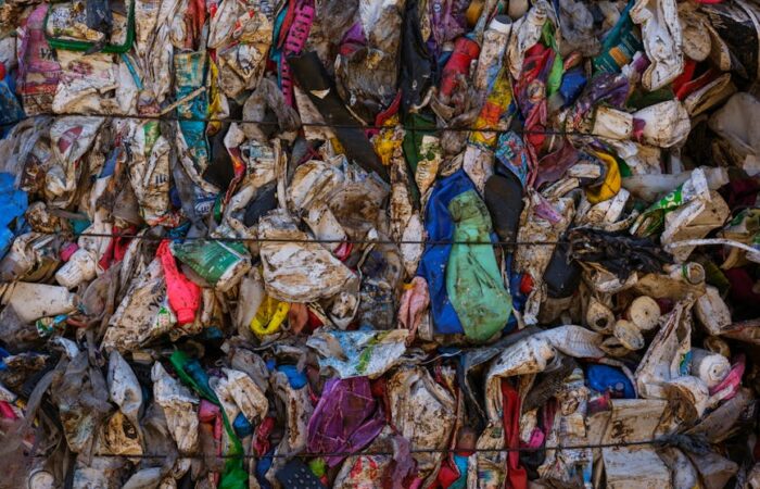 Infographic comparing fiber based and plastic packaging icons showing icons for renewability compostability and recyclability vs landfill and pollution for plastic in green and red tones